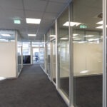 Büroflur mit Glaswänden und Aluminiumrahmen im modernen Innenausbau